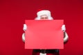 Santa Claus pointing in blank advertisement banner isolated on red background with copy space red leaf Royalty Free Stock Photo