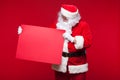 Santa Claus pointing in blank advertisement banner isolated on red background with copy space red leaf Royalty Free Stock Photo