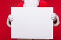 Santa Claus pointing in blank advertisement banner isolated on red background with copy space Royalty Free Stock Photo