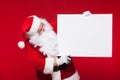 Santa Claus pointing in blank advertisement banner on red background with copy space Royalty Free Stock Photo