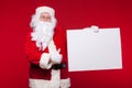 Santa Claus pointing in blank advertisement banner on red background with copy space Royalty Free Stock Photo