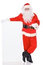 Santa Claus pointing on blank white wall, advertisement banner with copy space. Isolated on white background. Full Royalty Free Stock Photo