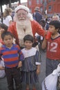 Santa Claus posing with homeless children at Christmas dinner, Los Angeles, California
