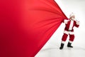 Santa Claus pulling huge bag full of christmas presents isolated on white background Royalty Free Stock Photo