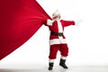 Santa Claus pulling huge bag full of christmas presents isolated on white background Royalty Free Stock Photo