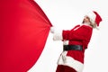 Santa Claus pulling huge bag full of christmas presents isolated on white background Royalty Free Stock Photo