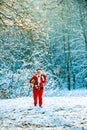 Santa Claus pulling huge bag of gifts on white nature background. Delivery christmas gifts. Winter Christmas greeting Royalty Free Stock Photo