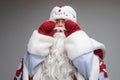Santa Claus put on hands to mouth to ask or congratulate somebody, studio festive portrait on gray background