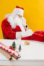 Santa Claus put his feet on the table and writes in a notebook Royalty Free Stock Photo