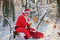 Santa Claus read Christmas wish list in the snow forest. Royalty Free Stock Photo