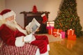 Santa claus reading newspaper on the couch Royalty Free Stock Photo
