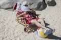 Santa Claus reading novel on sunny beach