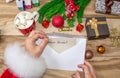 Santa Claus received a letter and holds it in his hands at the North Pole in Lapland, male hands on a wooden background with decor Royalty Free Stock Photo