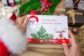 Santa Claus received a letter and holds it in his hands at the North Pole in Lapland, male hands on a wooden background with decor Royalty Free Stock Photo