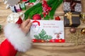 Santa Claus received a letter and holds it in his hands at the North Pole in Lapland, male hands on a wooden background with decor Royalty Free Stock Photo