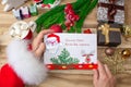 Santa Claus received a letter and holds it in his hands at the North Pole in Lapland, male hands on a wooden background with decor Royalty Free Stock Photo