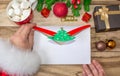 Santa Claus received a letter and holds it in his hands at the North Pole in Lapland, male hands on a wooden background with decor Royalty Free Stock Photo