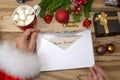 Santa Claus received a letter and holds it in his hands at the North Pole in Lapland, male hands on a wooden background with decor Royalty Free Stock Photo