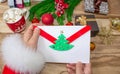 Santa Claus received a letter and holds it in his hands at the North Pole in Lapland, male hands on a wooden background with decor Royalty Free Stock Photo