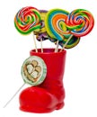 Santa Claus red boot, shoe with colored sweet lollipops, candys. Saint Nicholas boot with presents gifts. Royalty Free Stock Photo