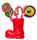 Santa Claus red boot, shoe with colored sweet lollipops, candys. Saint Nicholas boot with presents gifts. Royalty Free Stock Photo