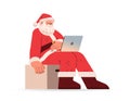 santa claus in red costume sitting on chair box and using laptop happy new year merry christmas holidays celebration Royalty Free Stock Photo