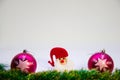 Santa Claus in a red hat in the center and on the sides of a purple ball on a white background