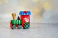 Santa Claus red toy train on background of golden bokeh. Selective focus. Christmas greeting card Royalty Free Stock Photo