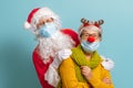 Santa Claus and reindeer in face masks during Covid-2019 Royalty Free Stock Photo