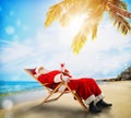 Santa Claus relaxing on a deckchair in a tropical beach