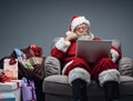 Santa Claus connecting with a laptop Royalty Free Stock Photo