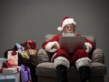 Santa Claus connecting with a laptop Royalty Free Stock Photo