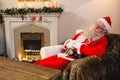 Santa claus relaxing on sofa in living room at home Royalty Free Stock Photo