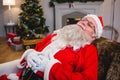 Santa claus relaxing on sofa in living room at home Royalty Free Stock Photo