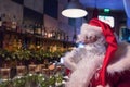 Santa Claus rests in bar with hot cappuccino