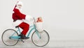 Santa Claus riding a bike with Christmas presents over white Royalty Free Stock Photo