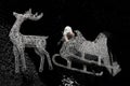 santa claus riding his sleigh pulled by reindeers. Christmas time event. santa claus with carriage deer on starry black sky