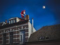 Santa Claus sitting on the roof of the house and puts the presents in the chimney. Christmas legend concept. Royalty Free Stock Photo