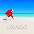 Santa Claus run at sandy ocean beach 2020 with Christmas sack Royalty Free Stock Photo