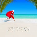 Santa Claus run at sandy ocean beach 2020 with Christmas sack Royalty Free Stock Photo