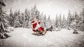 Santa Claus with sack of presents on the sled with a blurred snowy winter Christmas day background. Royalty Free Stock Photo