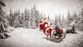 Santa Claus with sack of presents on the sled with a blurred snowy winter Christmas day background. Royalty Free Stock Photo