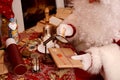 Santa Claus sealing a letter, looking through magnifier glass Royalty Free Stock Photo