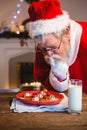 Santa Claus selecting cookies from plate Royalty Free Stock Photo