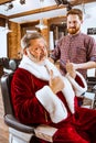 Santa claus shaving his personal barber