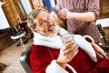 Santa claus shaving his personal barber