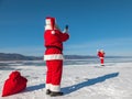 Santa Claus shoot on a smartphone of other Santa, walking on the