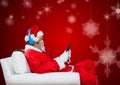 Santa claus sitting on chair and using mobile phone Royalty Free Stock Photo