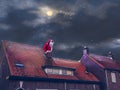 Santa Claus sitting in a chimney on a roof in the night. Merry Christmas and happy holidays! Mixed media Royalty Free Stock Photo