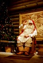 Santa Claus is sitting in his office by the fireplace